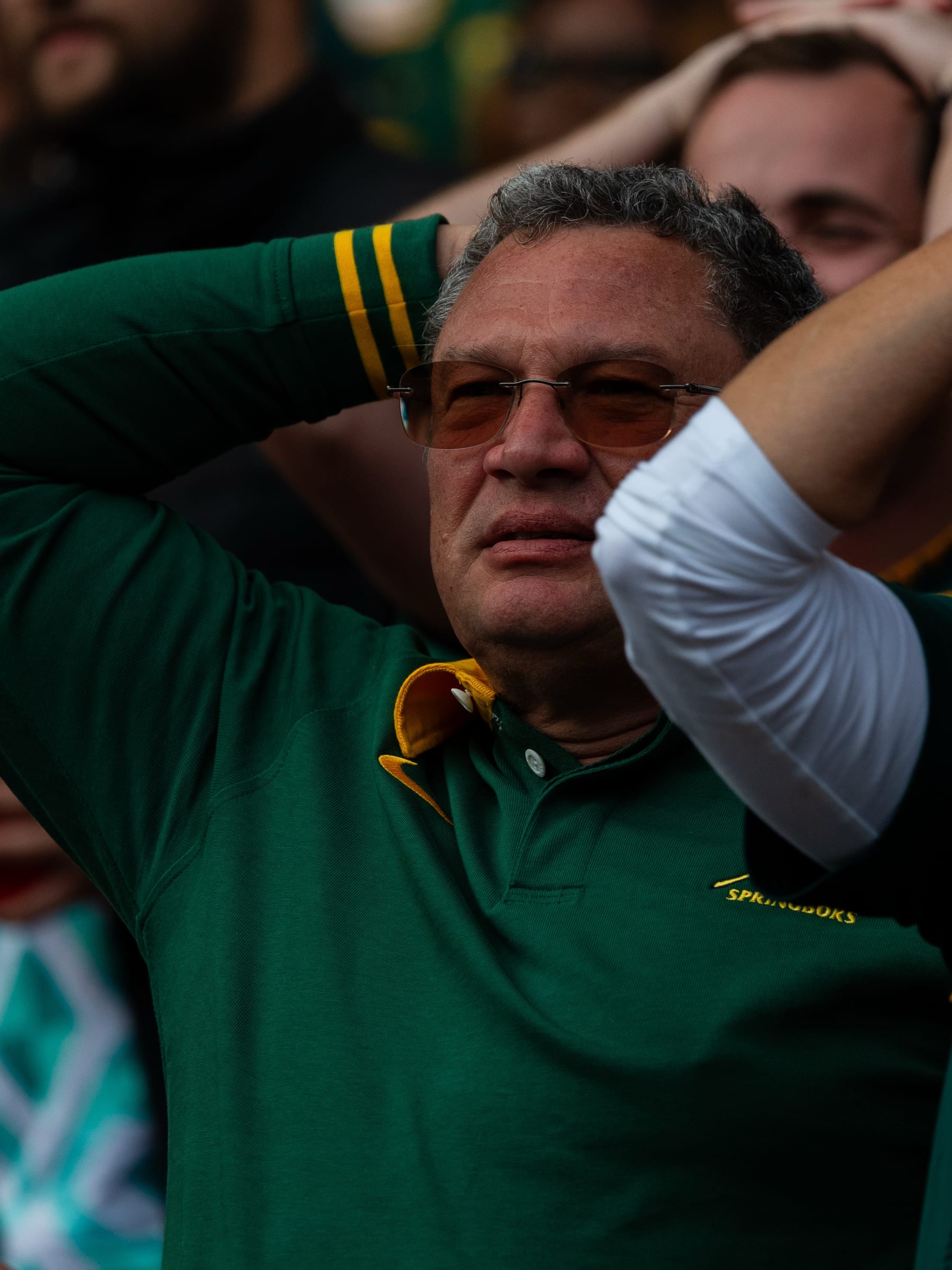 Springboks supporter in a green jersey with his hands behind his head during a tense moment