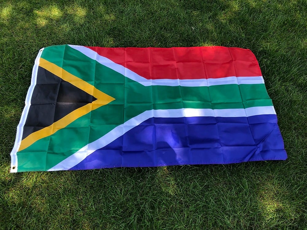 South African flag, 90 by 150cm, laid out on grass