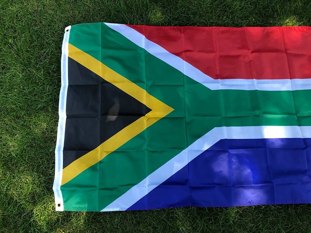 South African flag, 90 by 150cm, laid out on grass