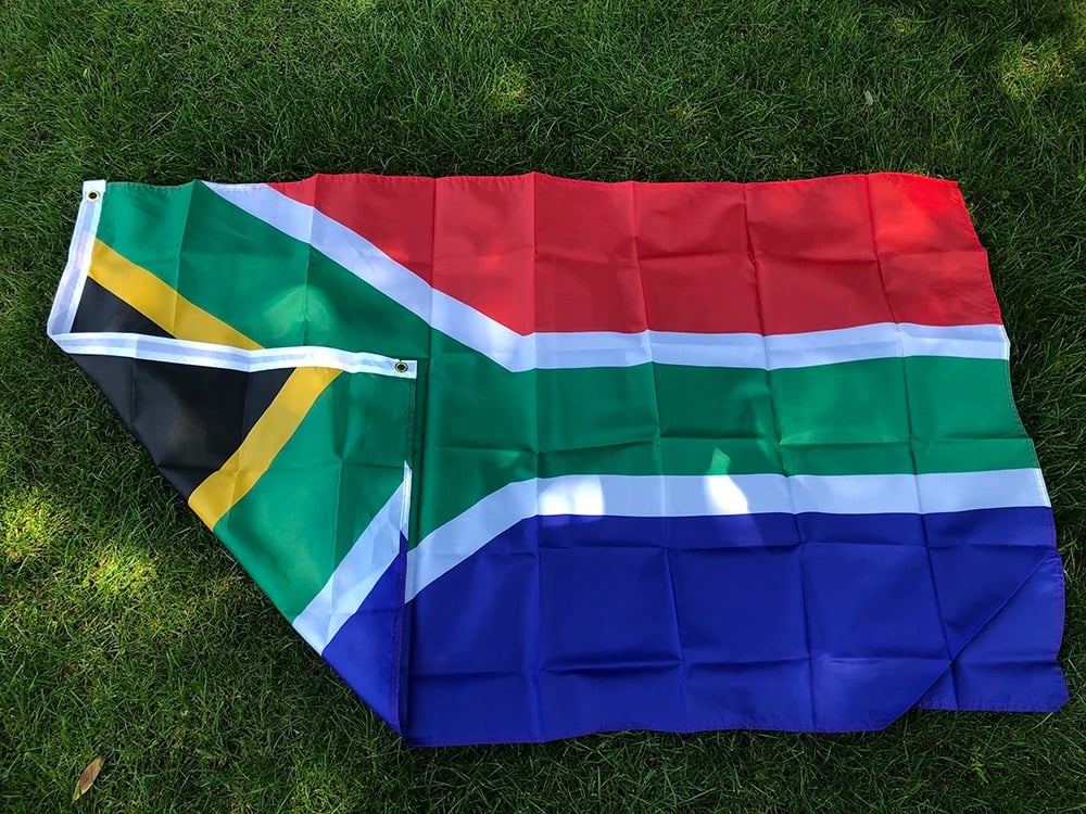 South African flag, 90 by 150cm, laid out on grass