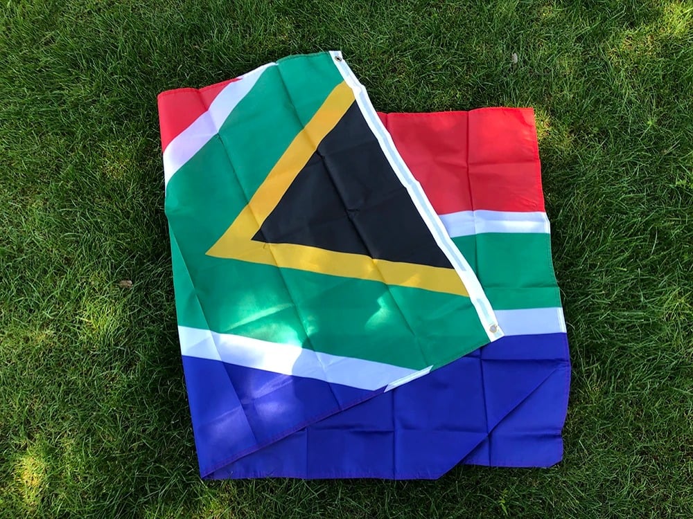 South African flag, 90 by 150cm, laid out on grass