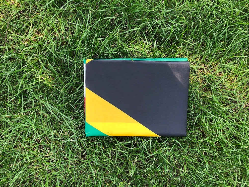 South African flag, 90 by 150cm, laid out on grass